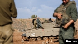 Israeli soldiers fire mortar shells near Israel's border with Gaza in southern Israel