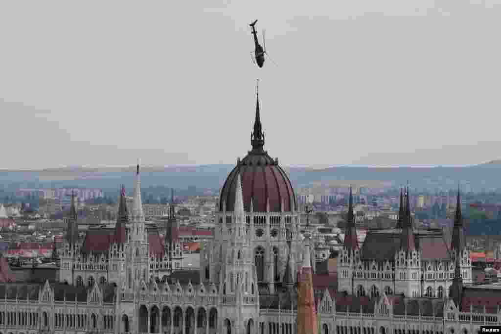 Helikopter AS 350 Angkatan Udara Hongaria terbang rendah di atas gedung parlemen yang ikonik, selama perayaan Hari St. Stephen di Budapest, Hongaria, 20 Agustus 2021. (Foto: Reuters)