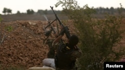 FILE - Syrian Democratic Forces (SDF) fighters shoot a drone they said belonged to Islamic State fighters on the bank of the Euphrates river, west of Raqqa city, April 8, 2017. 