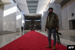 Fighters walk in the Syrian presidential palace in Damascus' Mount Qasyoun, Dec. 8, 2024.