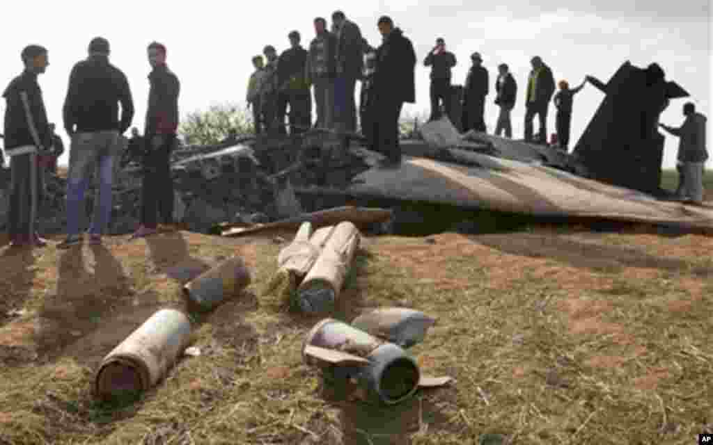 Libyans inspect the wreckage of a US F15 fighter jet after it crashed in an open field in the village of Bu Mariem, east of Benghazi, eastern Libya, March 22, 2011