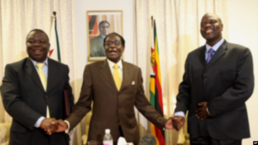 President Robert Mugabe, centre, shares a light moment with Morgan Tsvangirai, left, Zimbabwe's Prime Minister and his Deputy, Arthur Mutambara after giving their end of year message to the nation, at Zimbabwe House in Harare, Wednesday, Dec. 23, 2009