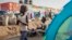 FILE - A young displaced girl washes clothes alongside a row of tents in the United Nations camp in Juba, South Sudan,  Feb. 12, 2014.