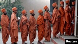 ریاست گجرات کے ایک پولنگ اسٹیشن پر ہندو سادھو اپنا ووٹ ڈالنے کے لیے قطار میں کھڑے ہیں۔ 14 دسمبر 2017