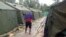 FILE - A man walking between tents at Australia's regional processing centre on Manus Island, in Papua New Guinea.