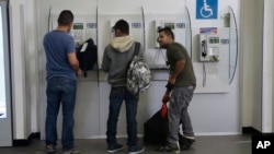 FILE - Mexican citizens use pay phones at the airport after being deported from the U.S., in Mexico City, Feb. 23, 2017. 