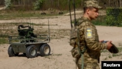 Un soldado ucraniano opera un vehículo por control remoto durante una exhibicion de equipos militares en un lugar no revelado de Ucrania el 13 de abril de 2024