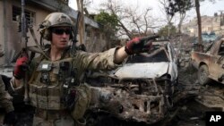 FILE - A U.S. soldier is seen at the site of a suicide bombing at a police compound in the Surobi district of Kabul, Feb. 21, 2014.