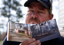 FILE - Bill Husa holds before-and-after photos of his home, Oct. 24, 2019, lost in the Camp Fire in Paradise, Calif. Husa's home is one of nearly 9,000 Paradise homes destroyed in the deadliest and most destructive wildfire in California history.