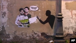 FILE - In this Feb. 19, 2020 photo, a Rome mural depicts detained Egyptian human rights advocate and student at the University of Bologna in Italy Patrick George Zaki, being hugged by Italian researcher Giulio Regeni, who was murdered in Cairo in 2016, is displayed near a park.