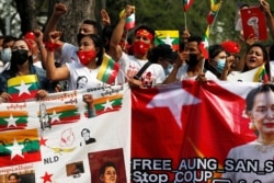 Myanmar citizens hold banners as they protest against the military coup in front of the UN office in Bangkok, Thailand, Feb. 22, 2021.