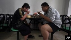 Wagonjwa walio na uzito kupita kiasi wakipata chakula katika kituo cha Aimin Fat Reduction huko Tianjin, China, Julai 24, 2008. 