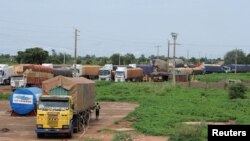 FILE - Trucks carrying food, humanitarian aid, and industrial equipment wait due to sanctions imposed by Niger's regional and international allies, in the border town of Malanville, Benin August 18, 2023.