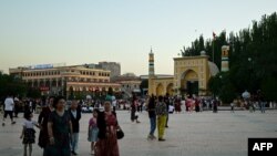 FILE - Uyghur people pass outside the Id Kah Mosque in Kashgar, China, on July 13, 2023. International delegates of the Organization of Islamic Cooperation praised Xinjiang's "prosperity and development” when they visited cities such as Kashgar in August 2023.