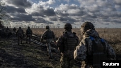 Prajurit Ukraina dari Brigade Artileri Terpisah ke-55 berjalan di posisi dekat garis depan kota Marinka, di tengah serangan Rusia ke Ukraina, di wilayah Donetsk, Ukraina 26 Desember 2023. (Foto: REUTERS/Viacheslav Ratynskyi)