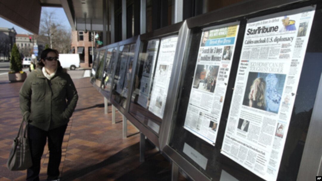 A woman reads the front pages of U.S. newspapers outside the Newseum in Washington.