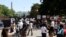 People gather to view protest signs now affixed to the fence around Lafayette Square at the scene where protesters clashed with police, near the White House in Washington, June 8, 2020.