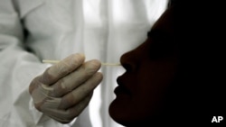 A doctor takes a nasal swab sample to test for COVID-19 at the Cocodrilos Sports Park in Caracas, Venezuela, Saturday, Sept. 19, 2020, amid the new coronavirus pandemic. (AP Photo/Matias Delacroix)