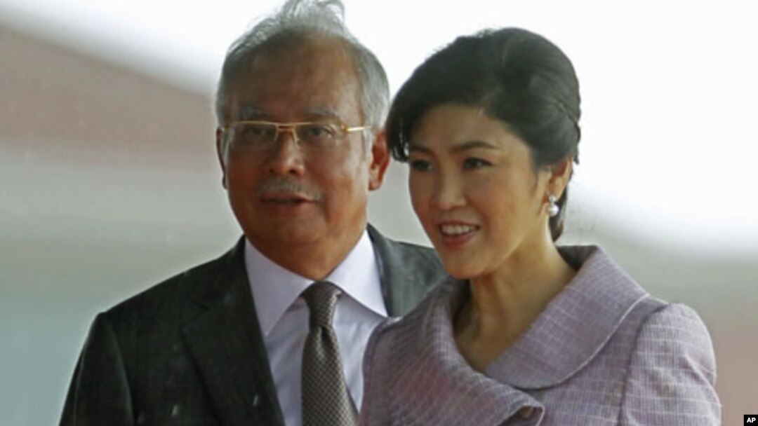Visiting Thailand's Prime Minister Yingluck Shinawatra and her Malaysian counterpart Najib Razak walk to step down from the stage after the welcoming ceremony outside Razak's office in Putrajaya near Kuala Lumpur, February 20, 2012.