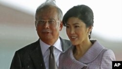 Visiting Thailand's Prime Minister Yingluck Shinawatra and her Malaysian counterpart Najib Razak walk to step down from the stage after the welcoming ceremony outside Razak's office in Putrajaya near Kuala Lumpur, February 20, 2012.