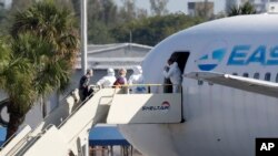 Passengers from the cruise ship Rotterdam board a charter plane at Fort Lauderdale–Hollywood International Airport on April 3, 2020, in Fort Lauderdale, Fla. 