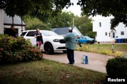 Sukarelawan Trump, Force Patrick Fuller (50 tahun), berbincang dengan penduduk setempat, Stephanie Brady di Erie, Pennsylvania, Amerika Serikat, 25 September 2024. (Hannah Beier/REUTERS)