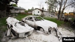 A burnt automobile and boat are seen as thousands of evacuees who fled a massive wildfire begin to return to their homes in Fort McMurray, Alberta, Canada, June 1, 2016.