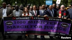 The Reverend Al Sharpton, third from right, leads a march to the Department of Justice during the 1,000 Ministers March for Justice in Washington, Aug. 28, 2017.