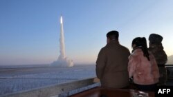 Pemimpin Korea Utara Kim Jong Un (Kiri) dan putrinya menyaksikan uji peluncuran rudal balistik antarbenua (ICBM) Hwasong Pho-18. Korea Utara berencana meluncurkan tiga satelit mata-mata lagi pada 2024. (Foto: ilustrasi)