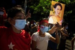 지난 9일 미얀마 양곤에서 열린 민주주의민족동맹(NLD) 지지 집회에서 참가자들이 아웅산 수치 국가고문의 사진을 들고 있다.