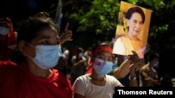 지난 9일 미얀마 양곤에서 열린 민주주의민족동맹(NLD) 지지 집회에서 참가자들이 아웅산 수치 국가고문의 사진을 들고 있다. 