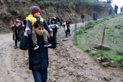 Migrants walk to the village of Skala Sikaminias, on the Greek island of Lesbos, after crossing the Aegean sea on a dinghy from Turkey, March 5, 2020.