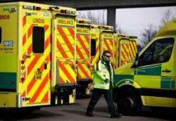 A paramedic walks amid ambulances outside London's Excel Centre, while it is being prepared to become a hospital for the treatment of coronavirus patients, in London, Britain, March 28, 2020.