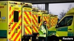 A paramedic walks amid ambulances outside London's Excel Centre, while it is being prepared to become a hospital for the treatment of coronavirus patients, in London, Britain, March 28, 2020.