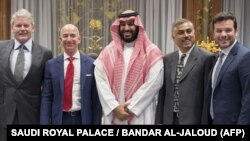 An alternative crop from a file handout picture released by the Saudi Royal Palace on November 9, 2016 shows Saudi Arabia's Crown Prince Mohammed bin Salman (C) posing for a picture with Amazon chief, Jeff Bezos (2nd L)