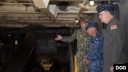 驻日美军司令马丁内斯空军中将(右)陪同日本海上自卫队官员参观美国海军日耳曼城号登陆舰