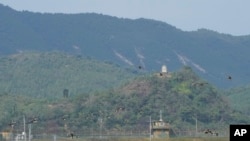 FILE - A North Korean loudspeaker, top left, a military guard post, top right, and a South Korean military guard post, bottom, are seen from Paju, South Korea, near the border with North Korea, Oct. 10, 2024. 