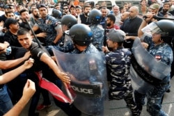 Riot police officers scuffle with Hezbollah supporters during ongoing anti-government protests in downtown Beirut, Lebanon, Oct. 25, 2019.