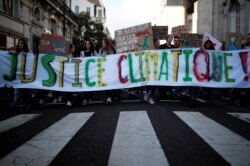 Youth for Climate activists hold a banner which reads: "climate justice" as they demonstrate during a day of protest to denounce the annual Black Friday shopping frenzy in Nantes, France, Nov. 29, 2019.