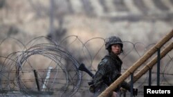 A South Korean soldier walks up the stairs at an observation post, near the demilitarized zone (DMZ) which separates the two Koreas, in Paju, north of Seoul, March 12, 2013. 