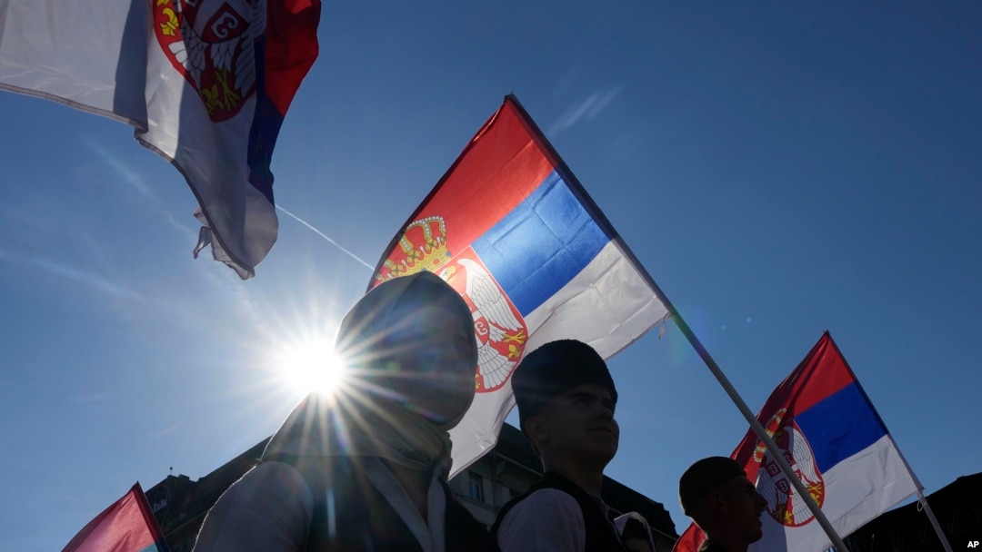 Ilustracija - ljudi nose zastave Srbije (AP Photo/Darko Vojinovic)