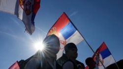 Orang-orang mengibarkan bendera Serbia selama pertemuan "Majelis Seluruh Serbia" di Beograd, Serbia, Sabtu, 8 Juni 2024. (Foto: AP)