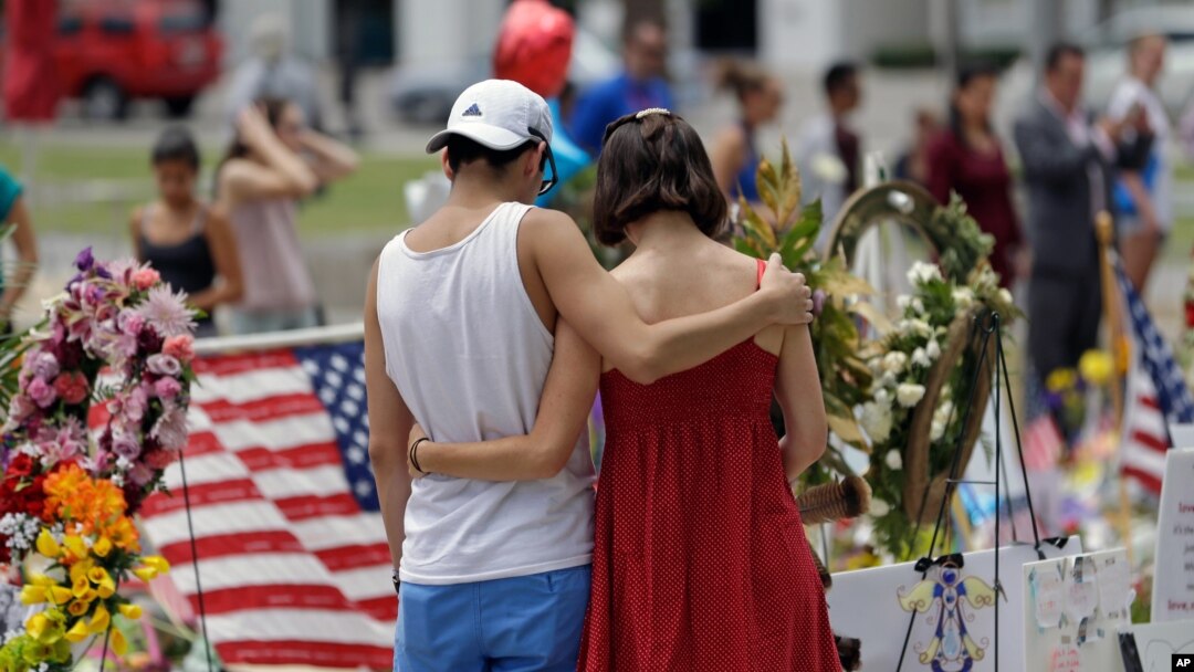A couple spends a quiet moment at a makeshift memorial honoring the victims of the Pulse nightclub mass shooting in Orlando, Fla., June 20, 2016.