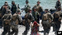 U.S. Marines from Company B, 1st Battalion Landing Team, 5th Marines, 31st Marine Expeditionary Unit and their Philippine counterparts, prepare to board their rubber boat with a mock captured suspect during joint exercises, April 15, 2013.