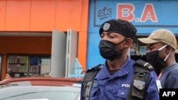 Policier moko azipi zolo na munoko na masque na misala mya kolamusa bato mpo na komibatela na COVID-19, na Kinshasa, RDC, 29 mai 2020.