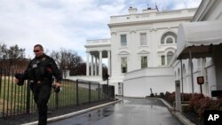 FILE - A Secret Service police officer walks past the White House, in Washington, March 22, 2019.