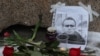 Bunga ditempatkan di samping potret pemimpin oposisi Rusia Alexey Navalny di monumen para korban penindasan politik setelah kematian Navalny, di Saint Petersburg, Rusia 16 Februari 2024. (REUTERS/Stringer)