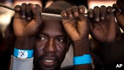 Samuel, 25 ans, du Nigeria, attend son tour pour quitter le navire de sauvetage de Golfo Azzurro au port de Pozzallo, au sud de la Sicile, Italie, 17 juin. 2017.