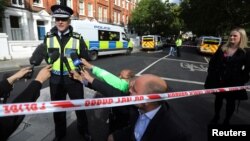 FILE - Deputy Chief Constable Adrian Hanstock of the British Transport Police makes a statement to the media after an incident at Parsons Green underground station in London, Britain, Sept. 15, 2017. 