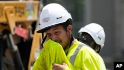 El trabajador de la construcción Fernando Padilla se limpia la cara mientras trabaja bajo el calor, el viernes 30 de junio de 2023 en Nashville, Tennessee.